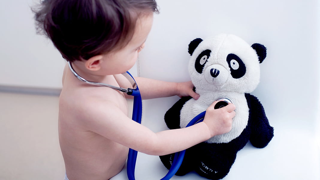 Little boy playing doctor with a panda patient
